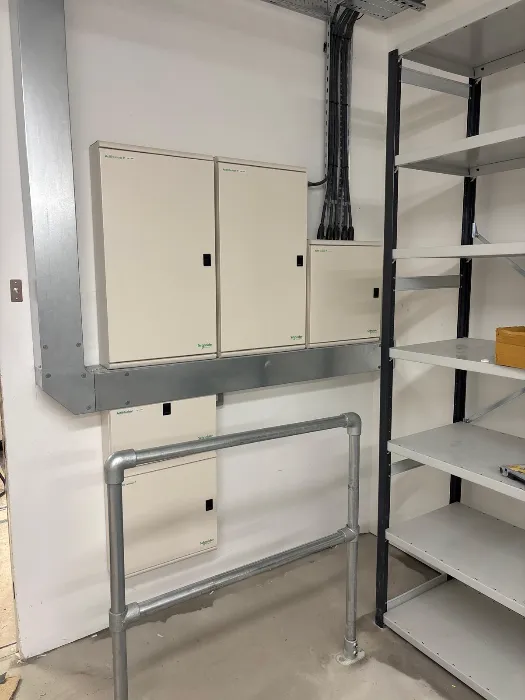 Galvanised conduit runs feeding wall-mounted enclosures in a back-of-house area